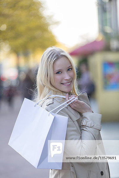 Hübsche blonde Frau mit Einkaufstaschen in der Innenstadt.