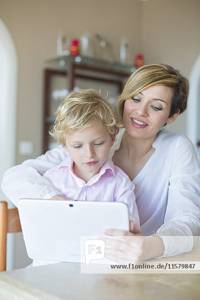 Woman and son with digital tablet at home