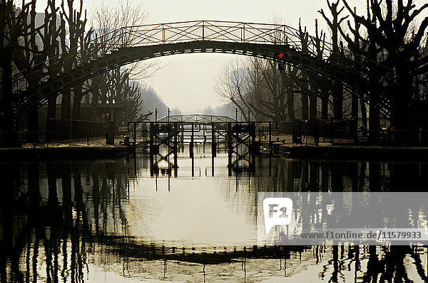 Frankreich  Ile de France  Paris  10. Bezirk  Canal St Martin in der Dämmerung  Bäume im Winter  Tor  Schleuse  Nachtlicht