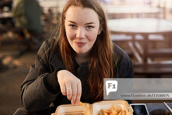 Porträt einer jungen Frau  im Freien  Chips essend  Bristol  UK