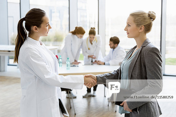 Female doctor shaking hands with consultant