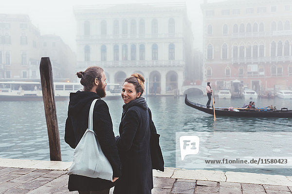 Rückansicht eines Ehepaares am Ufer des nebligen Kanals  Venedig  Italien