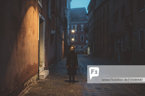 Porträt einer jungen Frau  die in der Abenddämmerung auf der Straße steht  Venedig  Italien