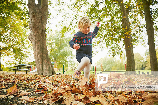 Mädchen spielt im Herbstlaub
