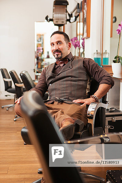 Portrait of mature male hairdresser in hair salon