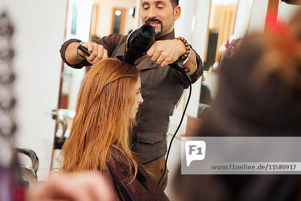 Herrenfriseur Föhnen Kunden rotes Haar im Friseursalon