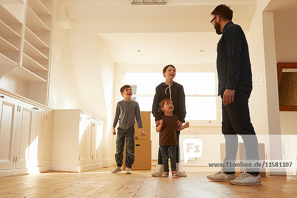 Mittlerer Erwachsener Mann  der drei Kinder in einem neuen Heim organisiert.