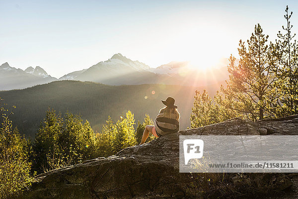 Frau auf Felsen sitzend  Blick nach hinten  Rückansicht  Squamish  Britisch-Kolumbien  Kanada