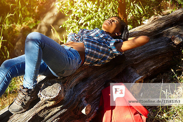 Junge Frau auf umgestürztem Baum liegend  Kapstadt  Südafrika