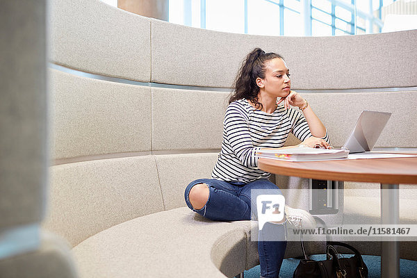 Universitätsstudent arbeitet in einem modernen Sitzbereich