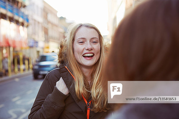 Two female friends talking in street