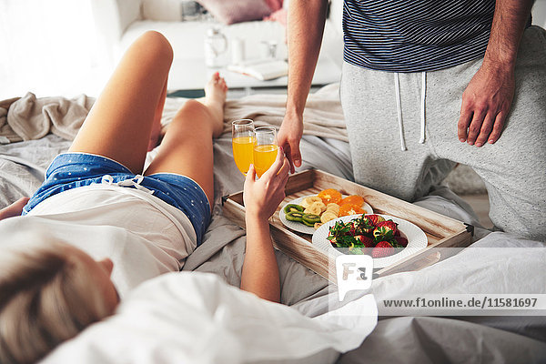Couple having breakfast in bed  mid section