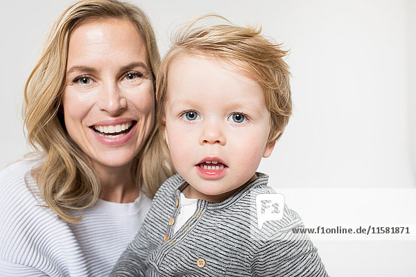 Porträt von Mutter und Sohn vor weißem Hintergrund  lächelnd