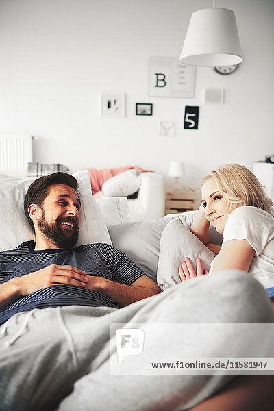 Couple relaxing on bed  smiling
