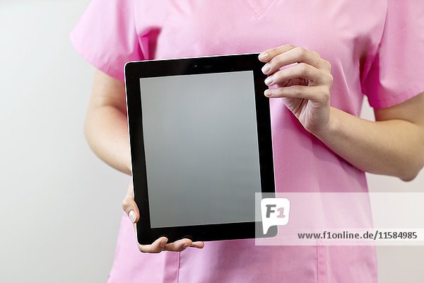 Female nurse holding digital tablet.