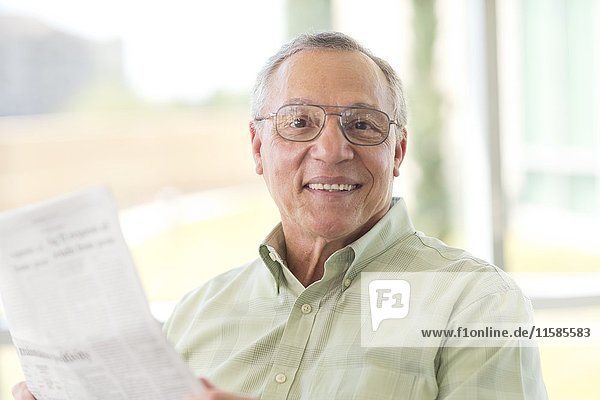 Senior man reading newspaper.