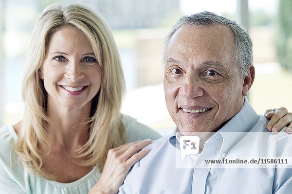 Senior man and mature woman smiling towards camera.