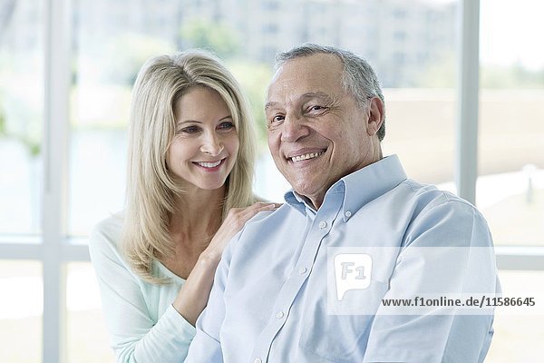 Senior man and mature woman smiling towards camera.