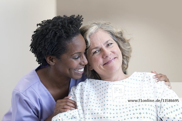 Nurse comforting female patient  smiling.