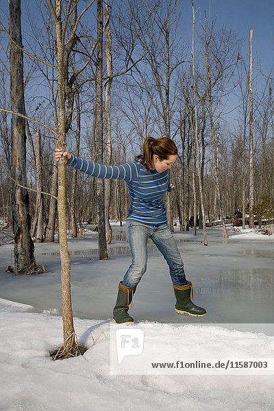 Frau testet Eis am Teich