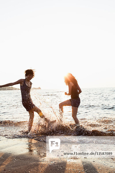 Frauen spielen in Wellen am Strand