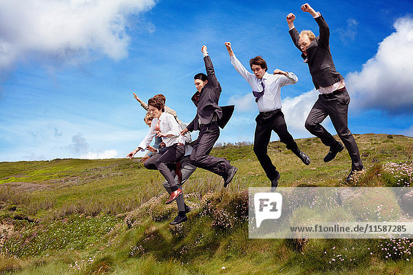 Businessmen jumping for joy outdoors