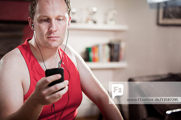 Mittlerer erwachsener Mann mit Kopfhörer und MP3-Player