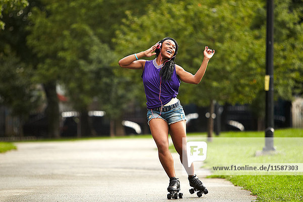 Young woman rollerskating and listening to music