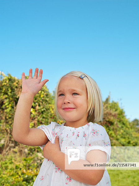 Young girl holding up hand