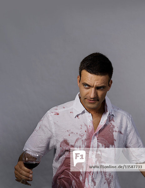 Mann mit Rotwein auf seinem Hemd