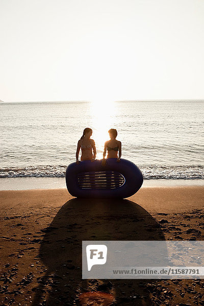 Women with inflatable boat on beach
