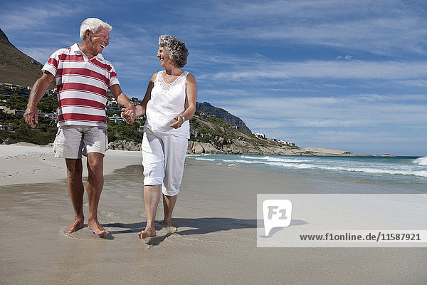 Älteres Paar beim gemeinsamen Strandspaziergang