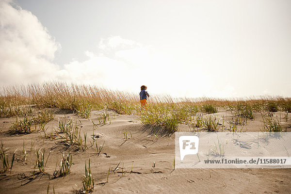 Boy running on sand dunes
