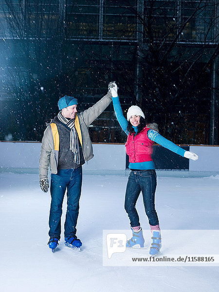 Couple holding hands on an ice rink