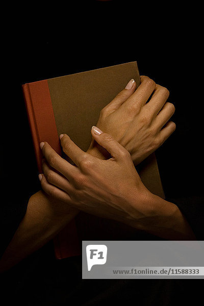 Hands clasped over book