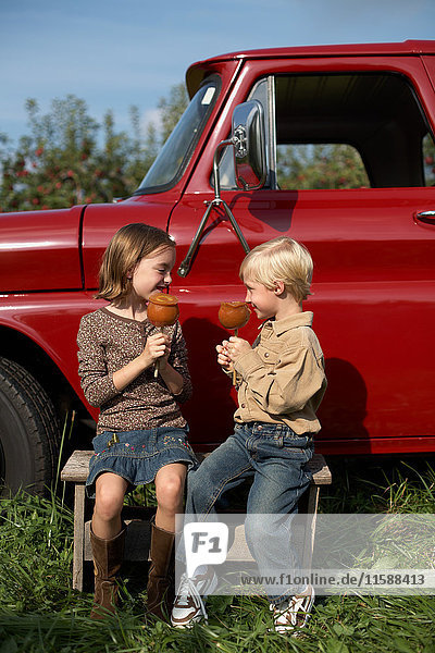 Junge und Mädchen essen Toffee-Äpfel per Lastwagen