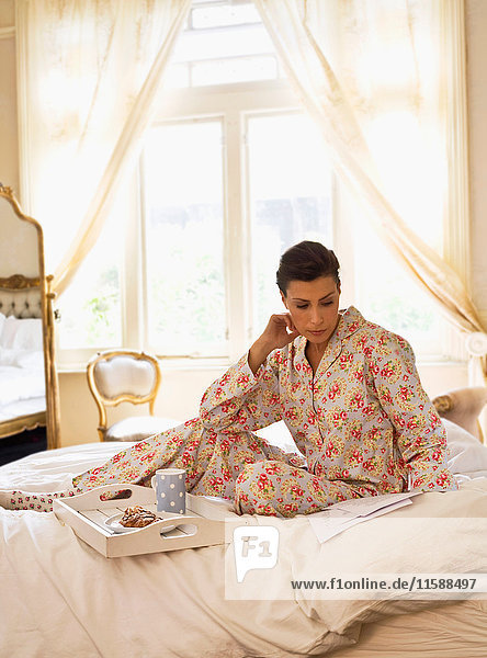 Junge Frau im Bett mit Pyjama
