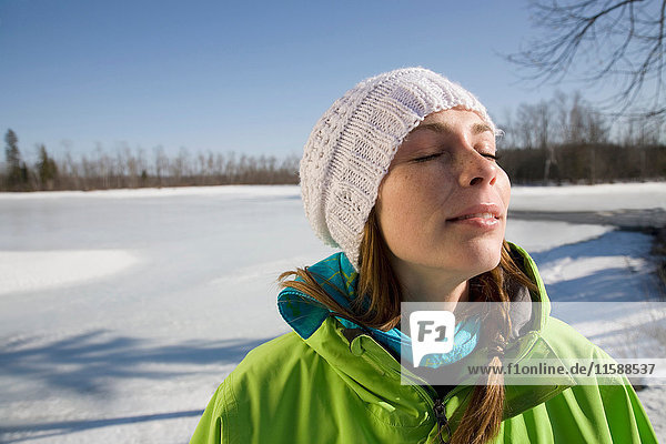 Frau entspannt sich am zugefrorenen See
