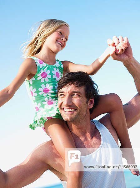 Tochter und Vater spielen am Strand