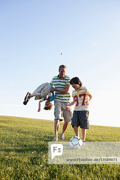 Vater und Jungen beim Fussballspielen