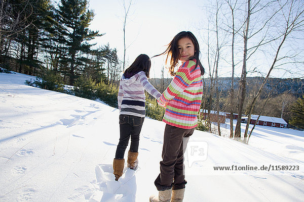 Zwei Mädchen laufen im Schnee