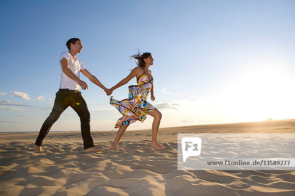 Young couple walk in sand
