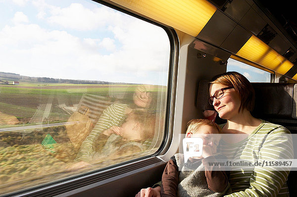Mother and son asleep on train