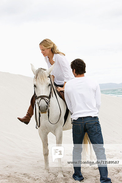 Frau und Mann mit Pferd am Strand