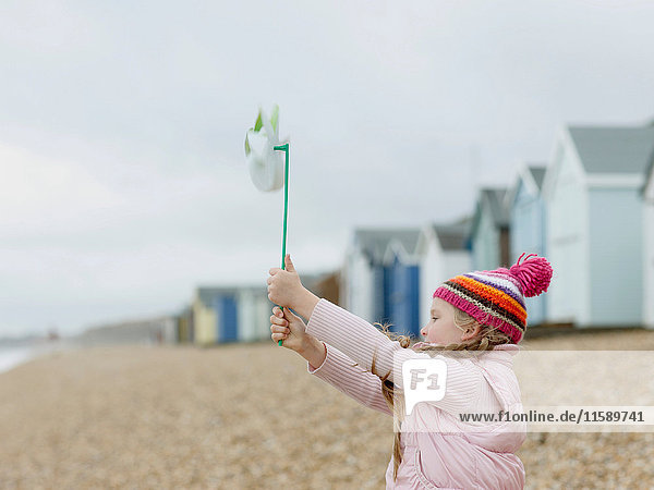 junges Mädchen mit Windmühle am Strand