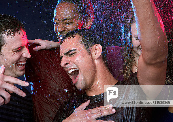 Group of friends dancing in the rain