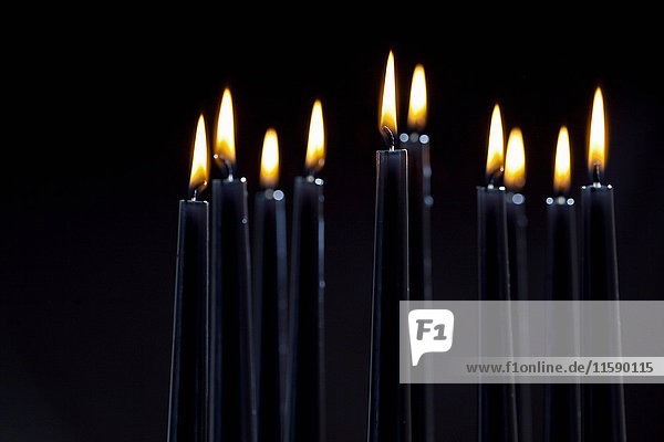 Nahaufnahme von angezündeten schwarzen Kerzen