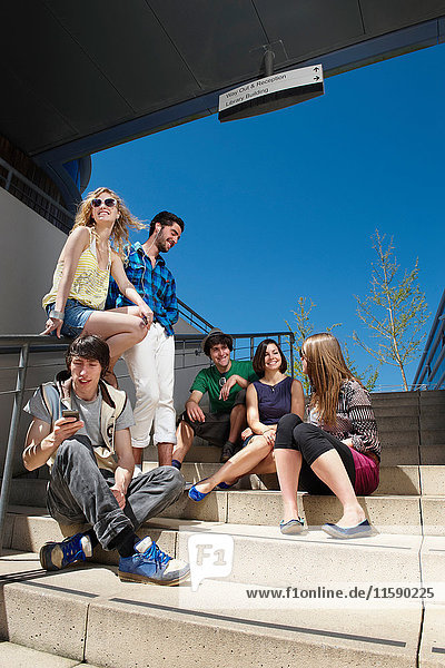 Gruppe junger Leute auf Stufen sitzend