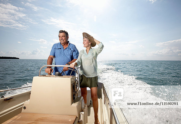 Älteres Ehepaar am Steuer eines Motorbootes