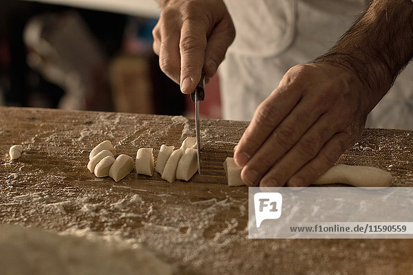 Close up of chef cutting gnocchi dough